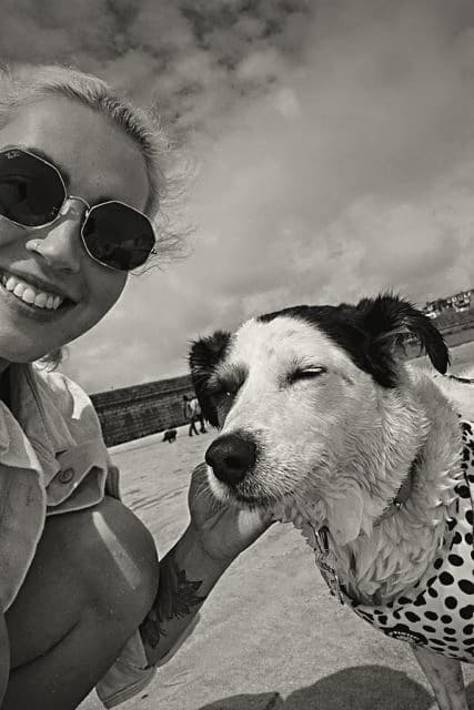 Natalie and Frankie on a British beach, Frankie resting her head in Natalie's hand